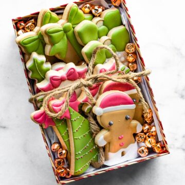 An overhead view of gluten-free cut-out christmas cookies arranged in a gift box.