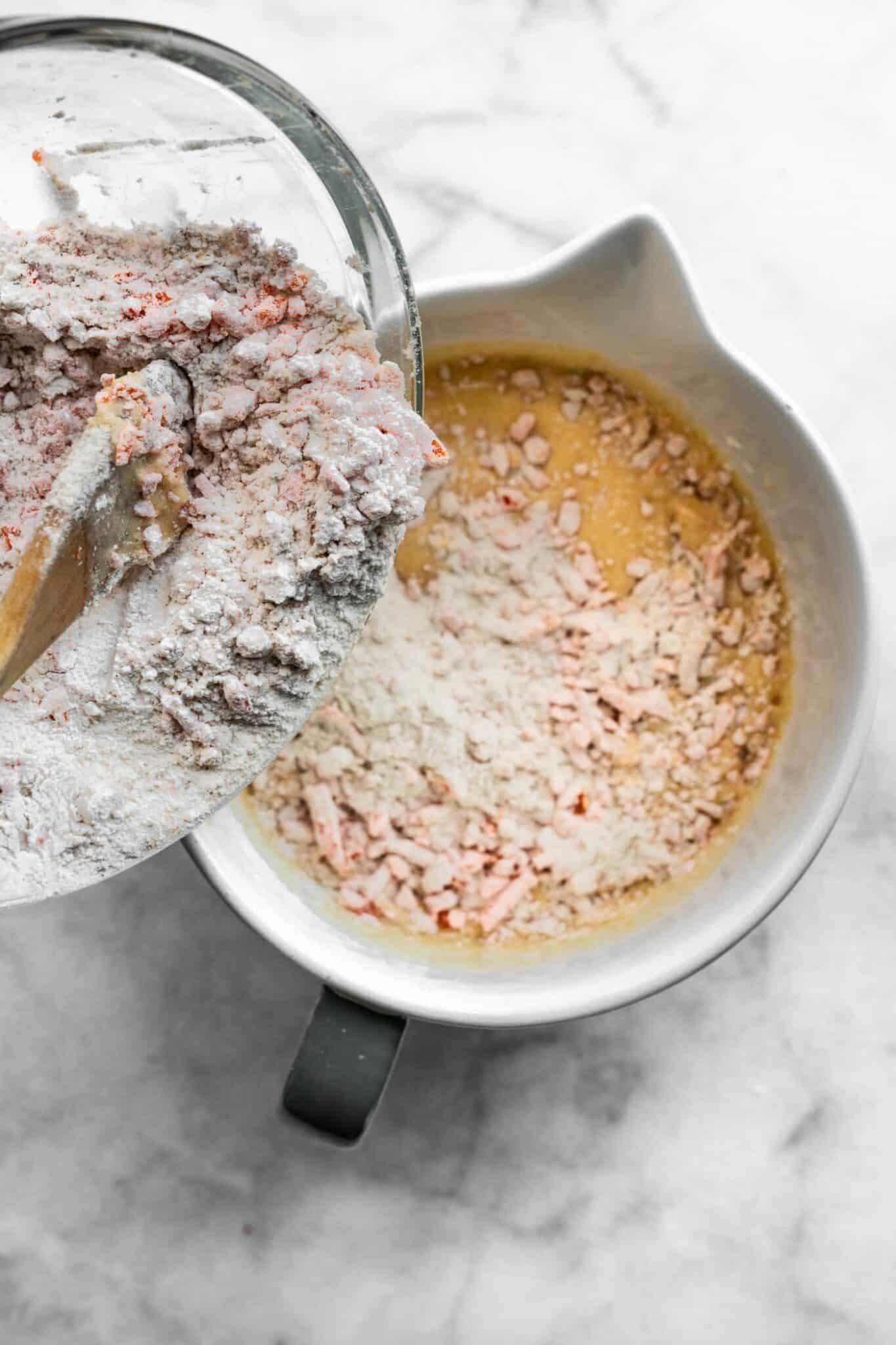 Pouring dry ingredients into the wet ingredients bowl.