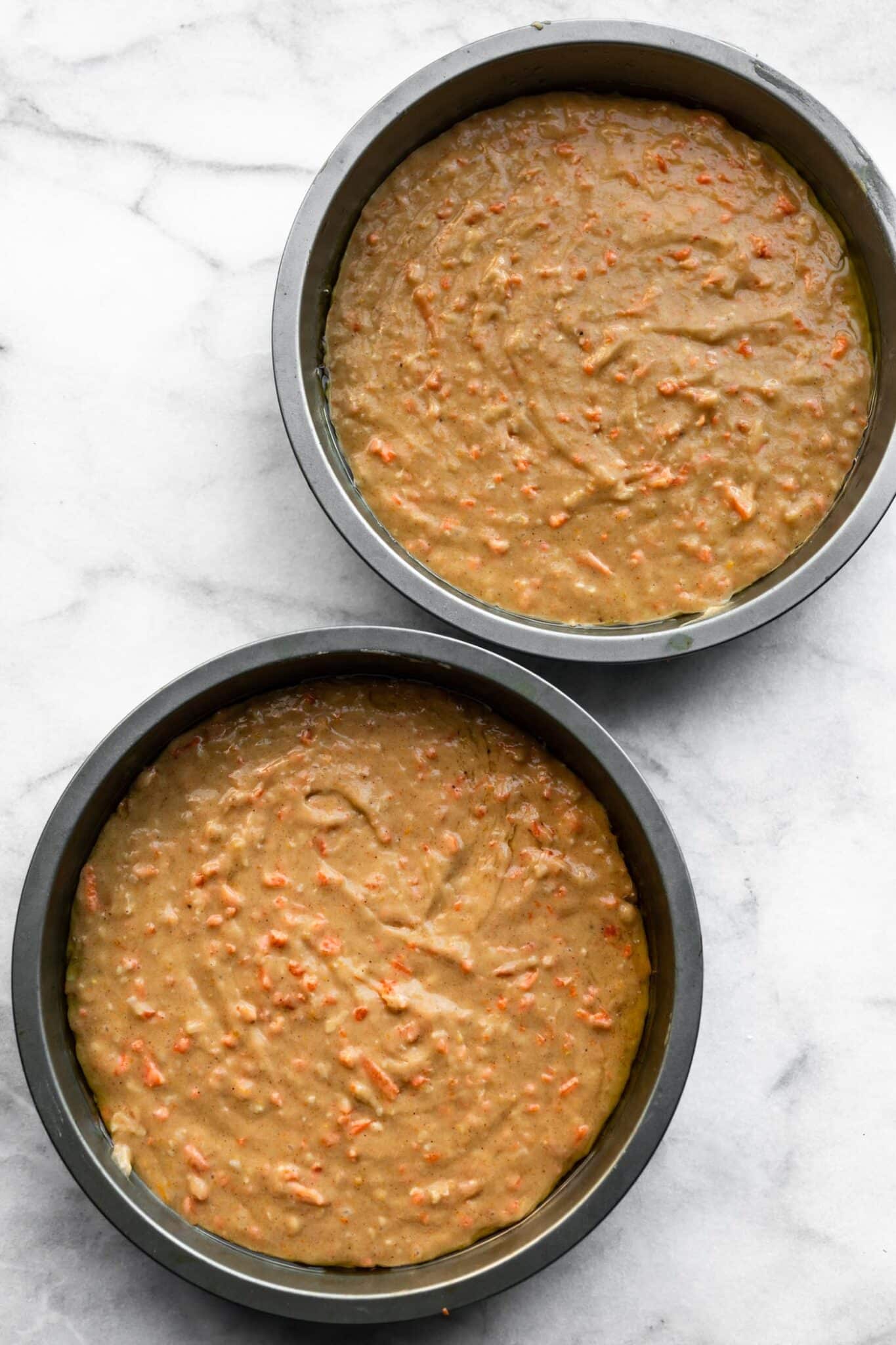 Carrot cake batter in two round cake pans.
