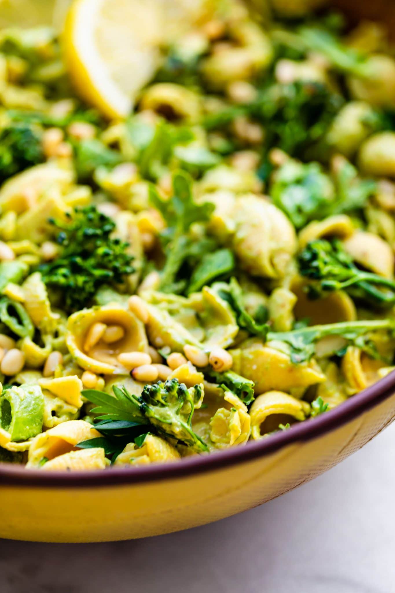 Close up photo of a vegan green goddess pasta salad in a bowl.