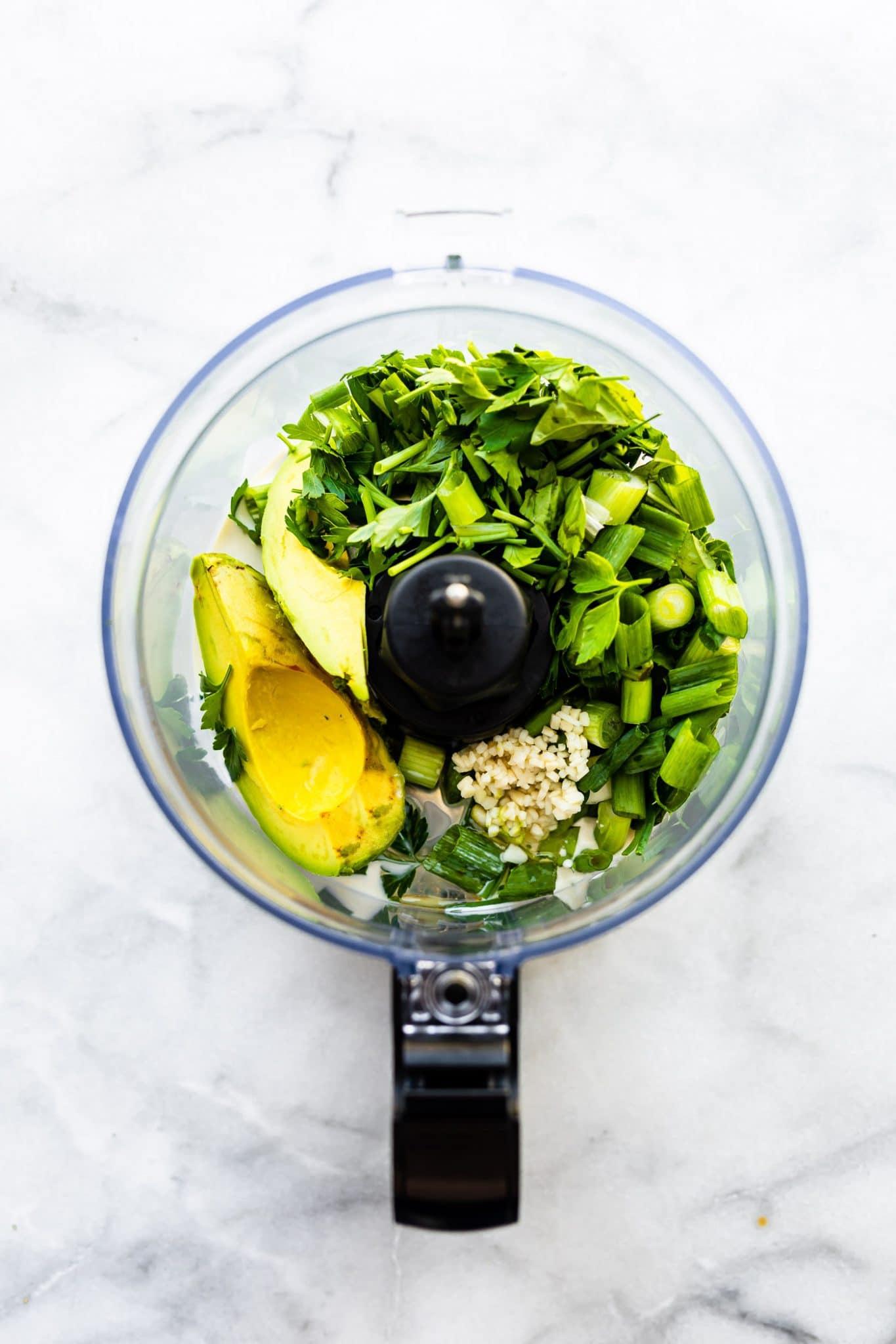 Green goddess salad dressing ingredients in a food processor.