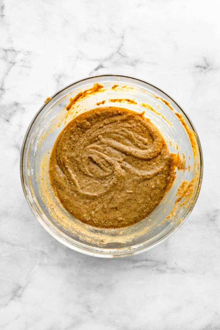 Gluten free muffin batter in a glass bowl.