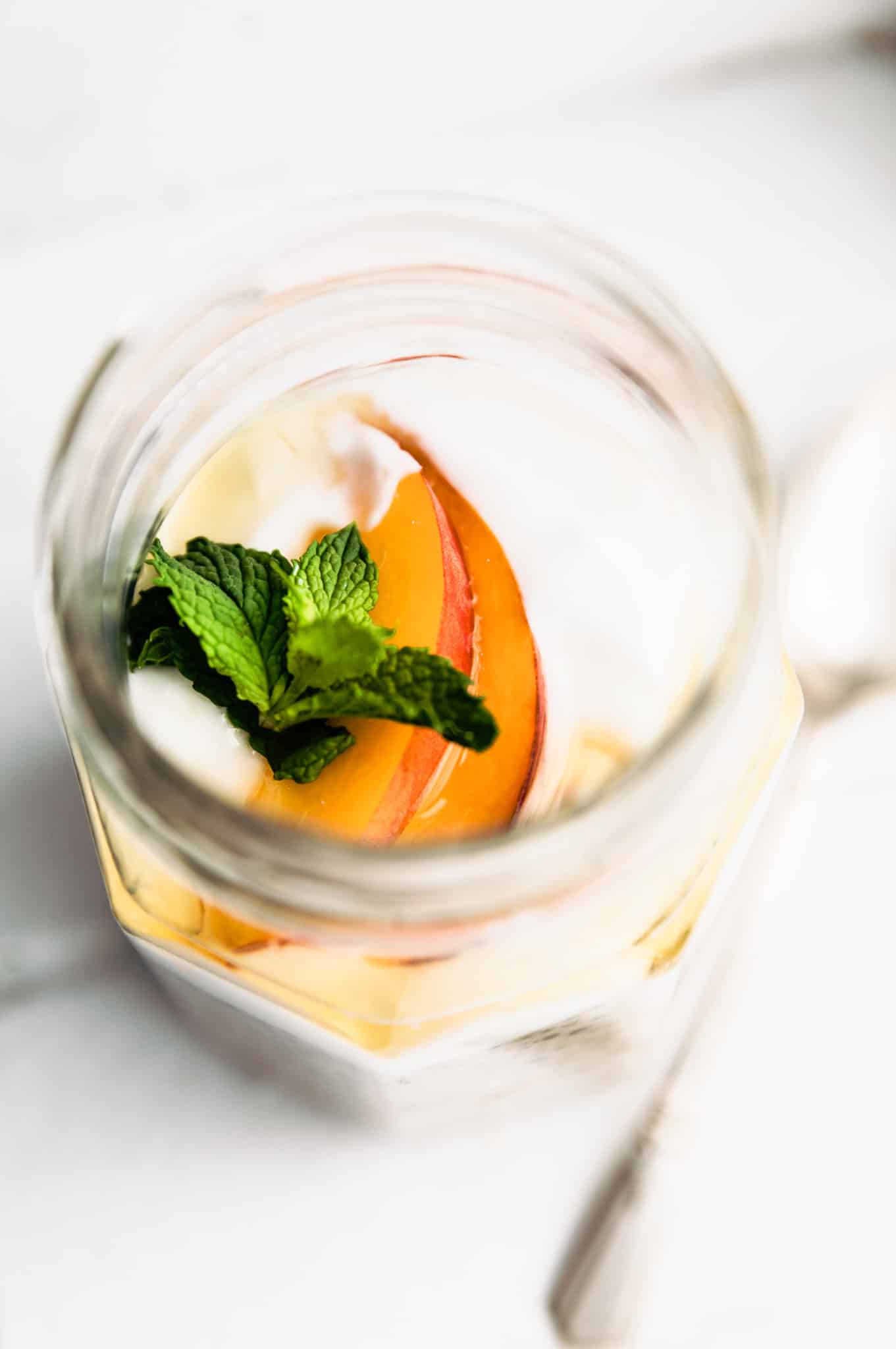 overhead image of a slice of peach and fresh mint on top of chia pudding