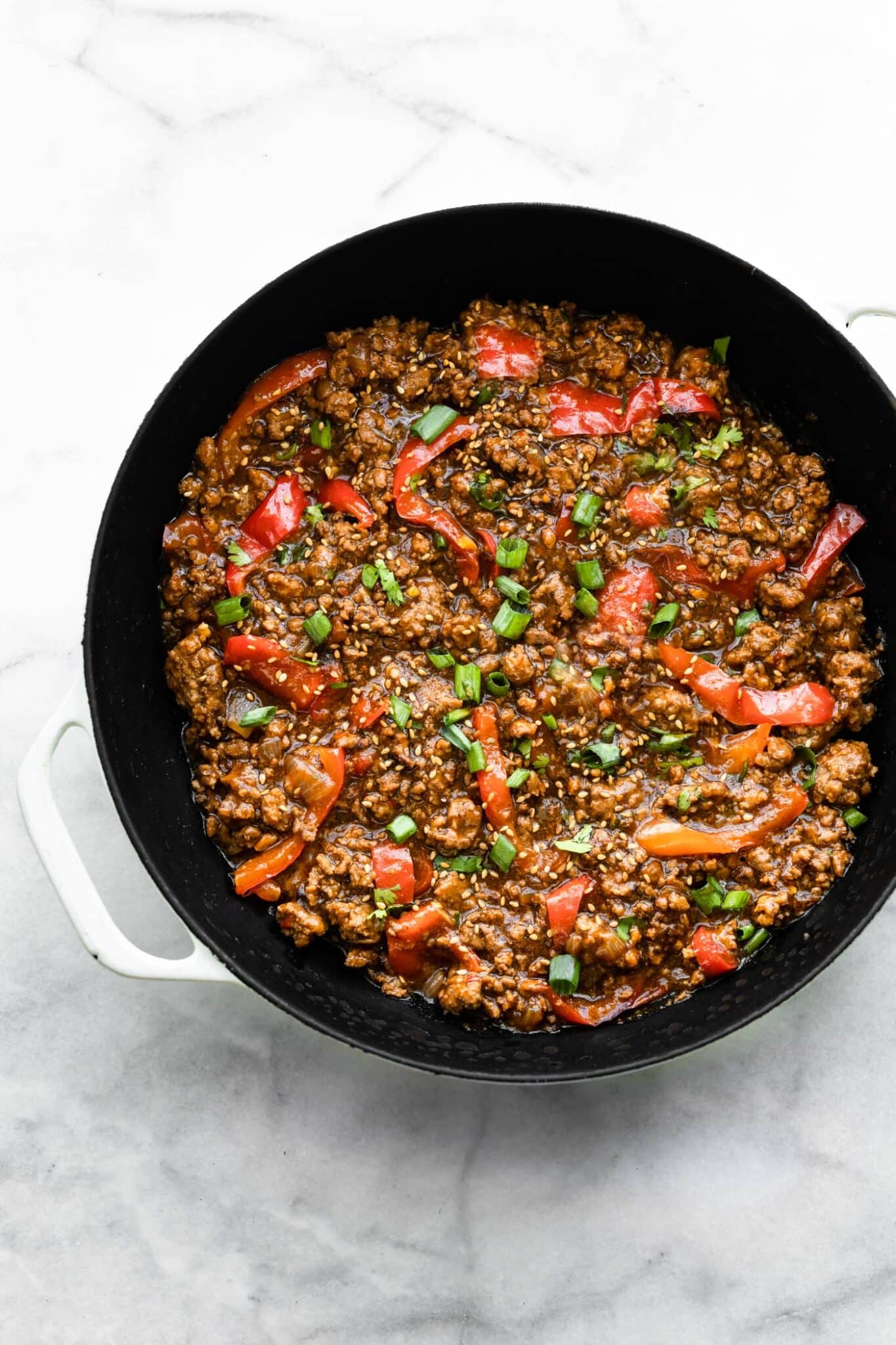 Overhead photo of Korean beef bulgogi in a glazed cast iron pan.