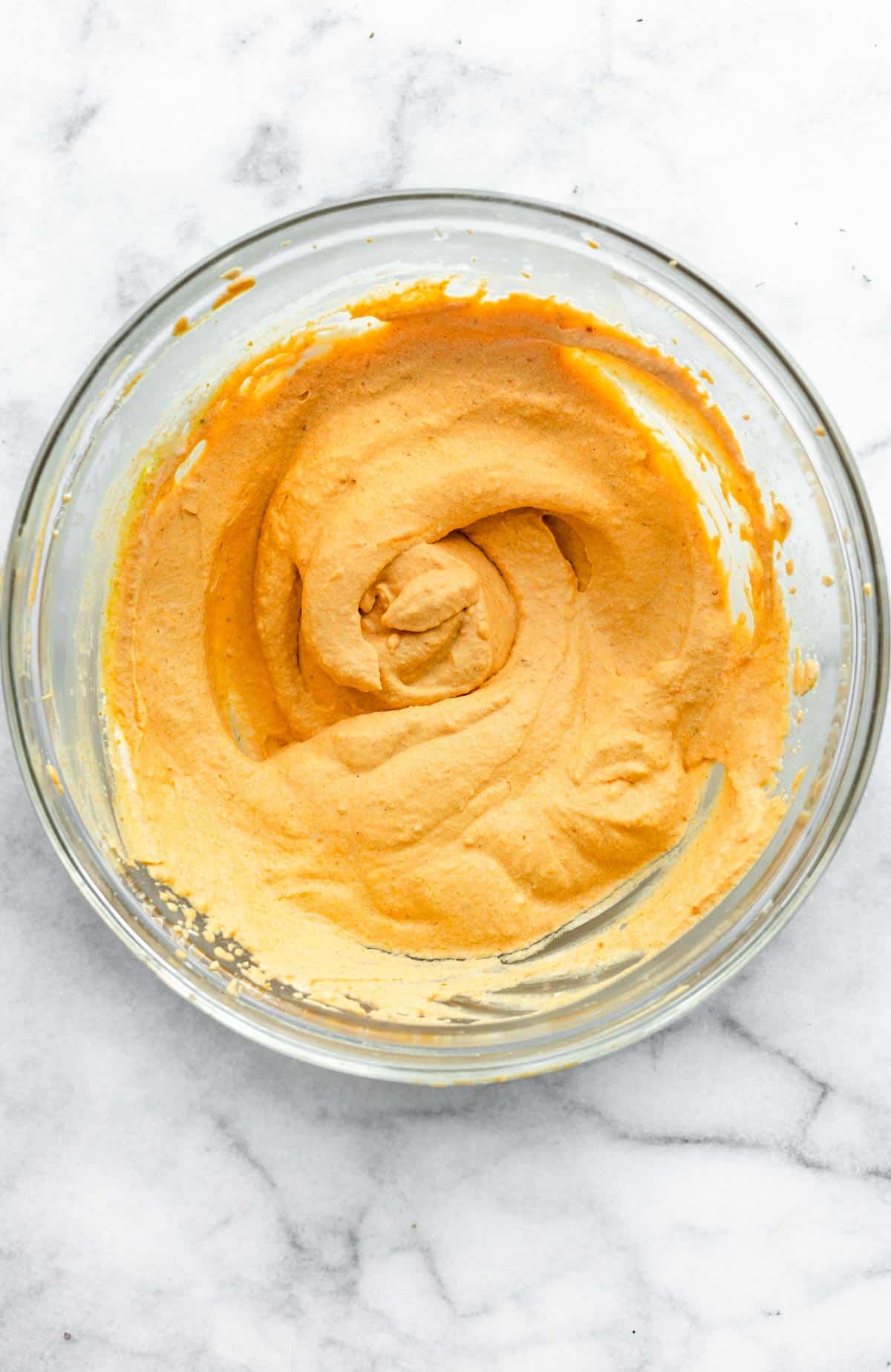 a glass bowl full of whipped vegan pumpkin pie dip