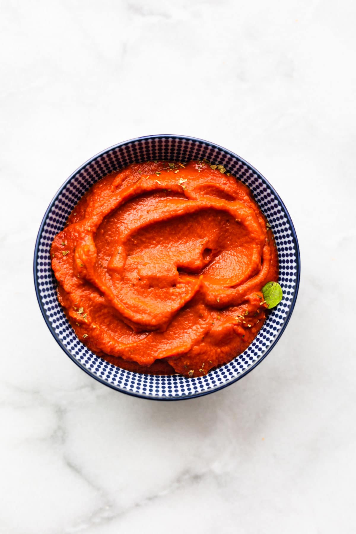 An overhead photo of a tomato sauce alternative (nomato sauce) in small blue bowl.