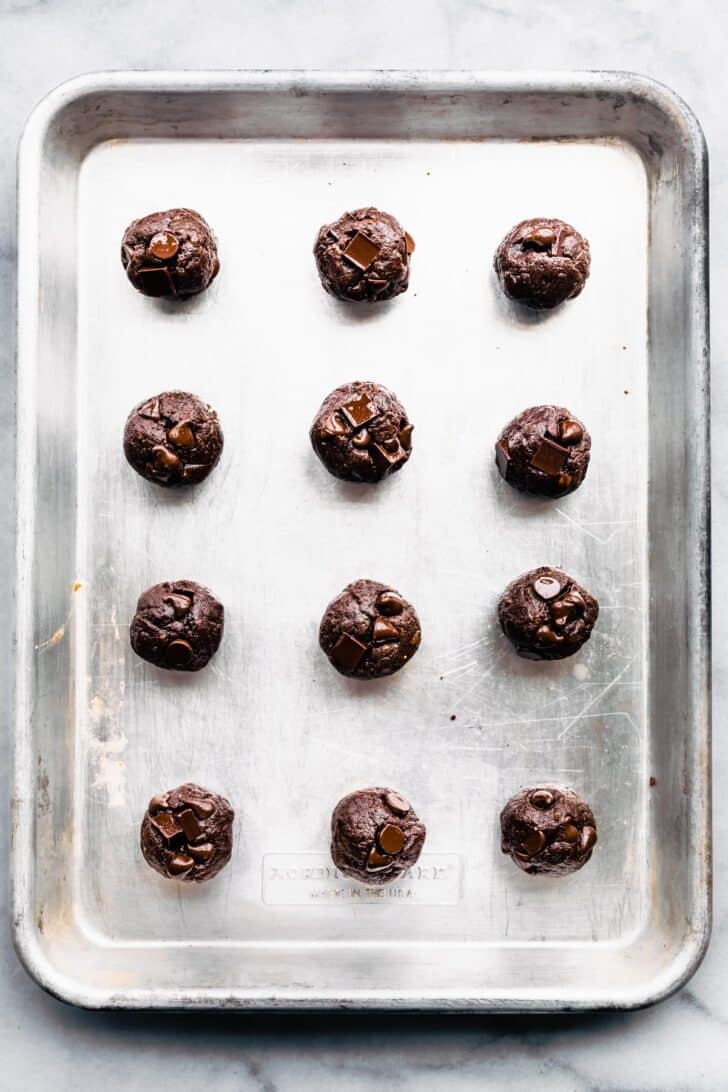 12 chocolate nut-free protein balls on a baking sheet.
