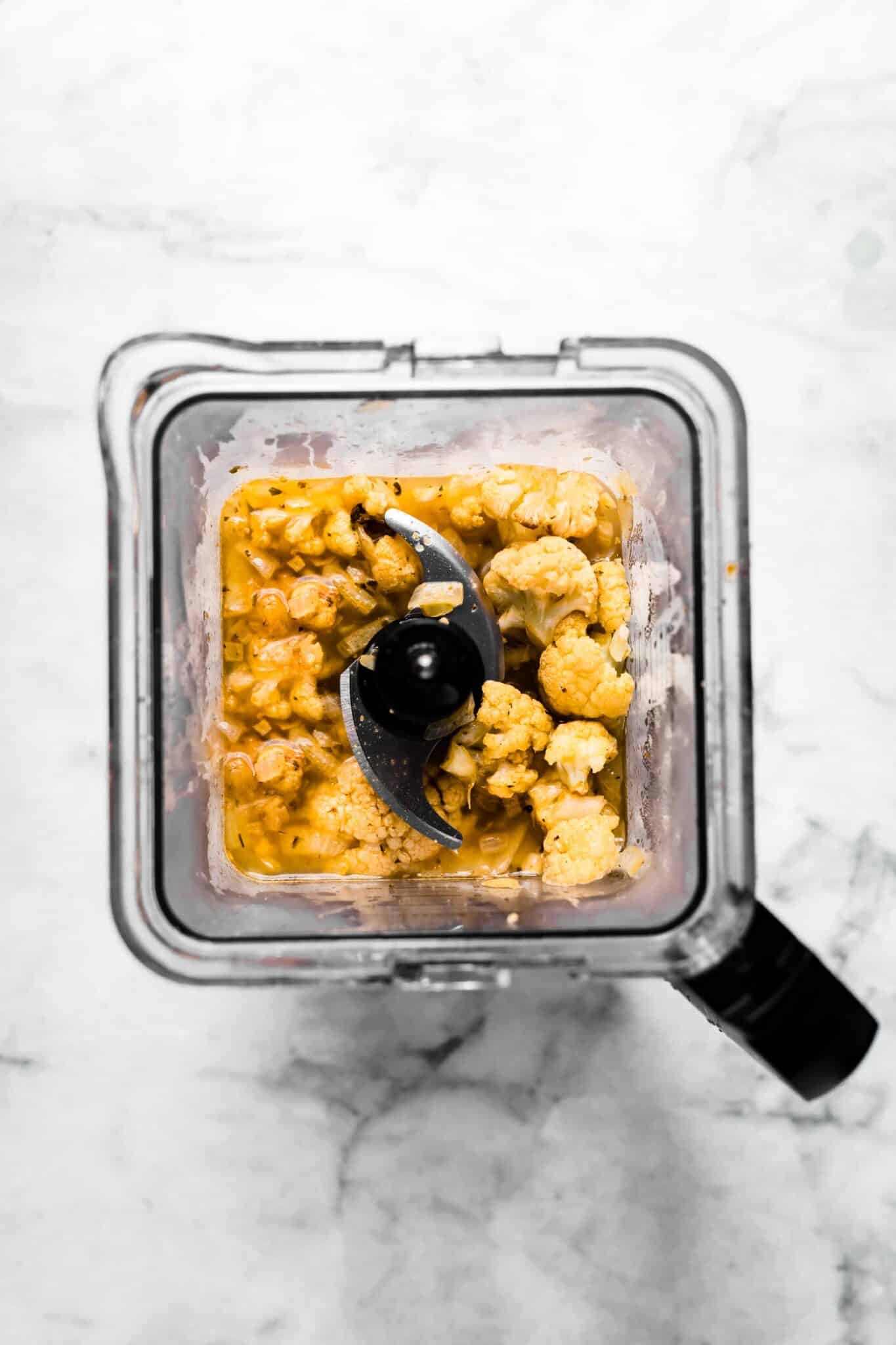 Roasted cauliflower soup in a blender ready to be pureed.