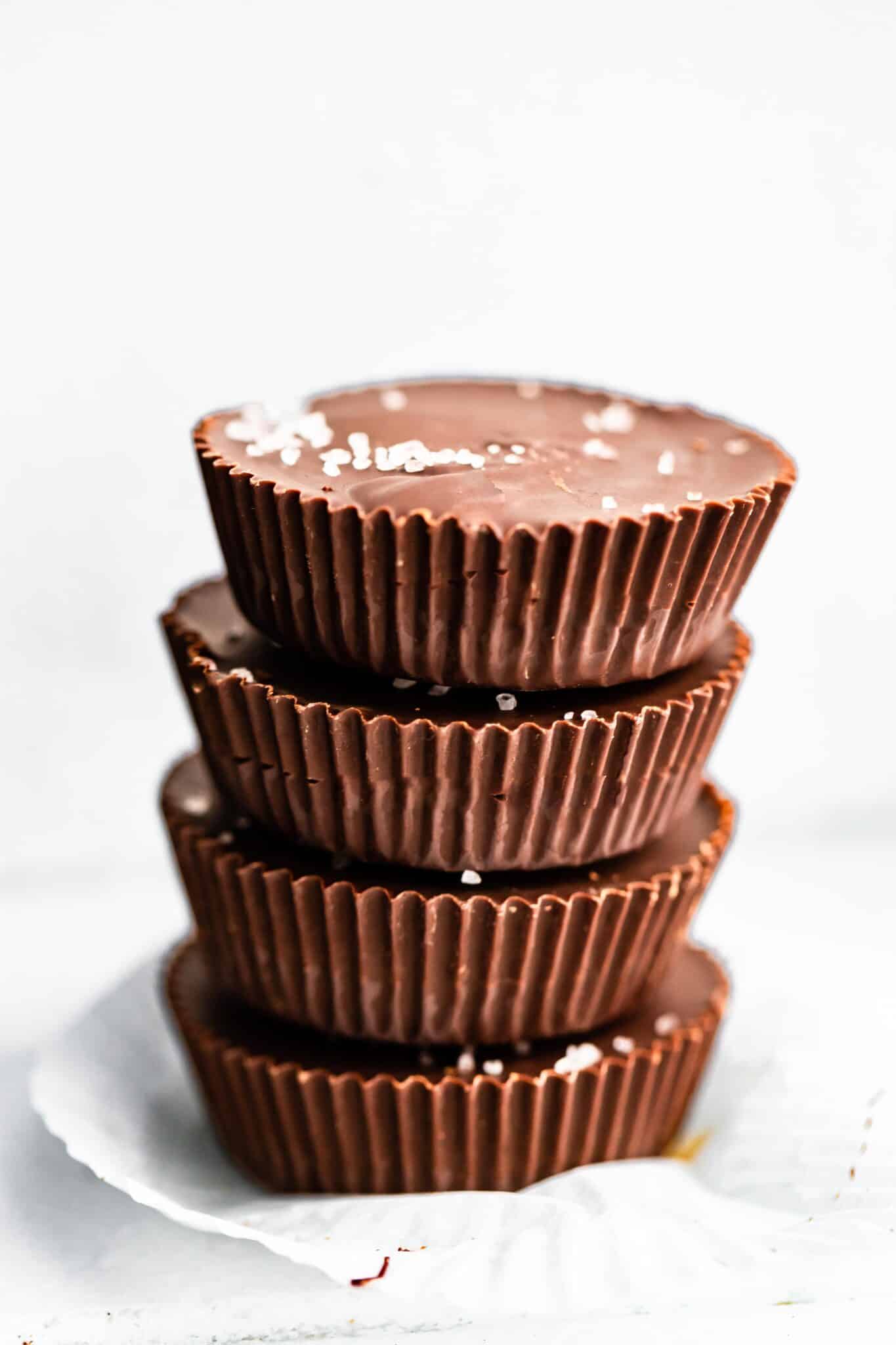 Four chocolate almond butter cups with banana stacked with sea salt flakes on top.