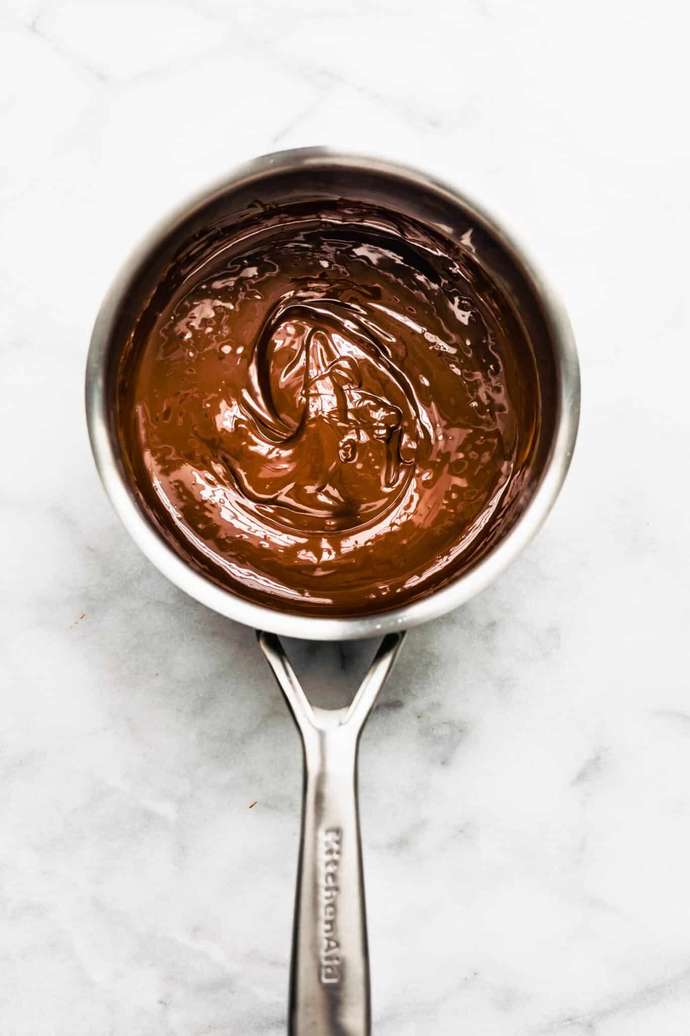 Overhead photo of a stainless steep pot with melted chocolate.