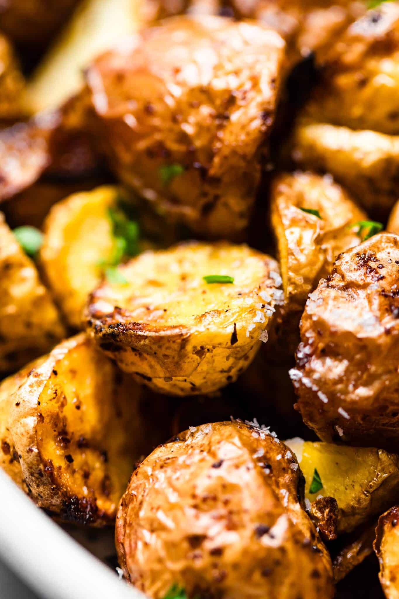 close up of Air-fried baby potatoes in a white bowl garnished with parsley