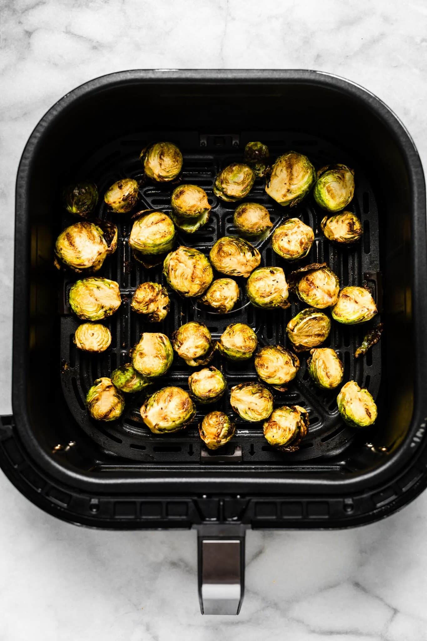 crispy Brussels sprouts in air fryer basket.