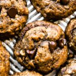 Overhead photo of breakfast cookies topped with chocolate chips on a sheet pan.