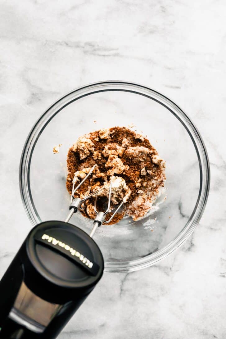 hand mixer beating butter and brown sugar in a bowl