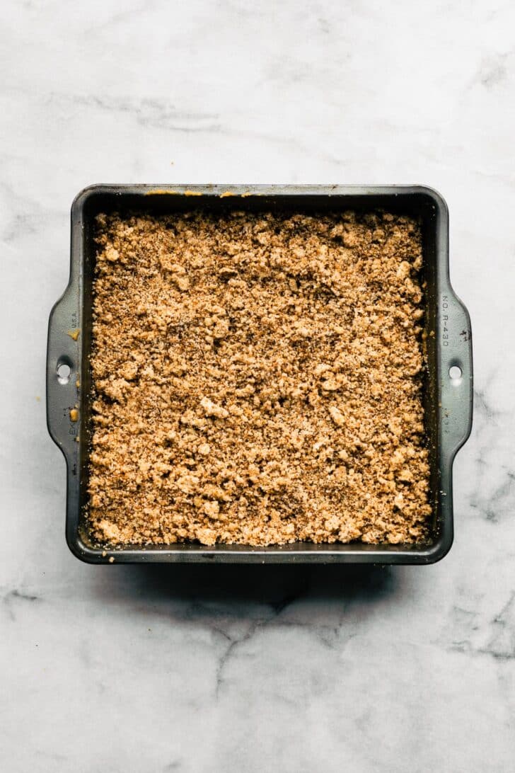 almond flour blueberry cake batter in a pan with crumble
