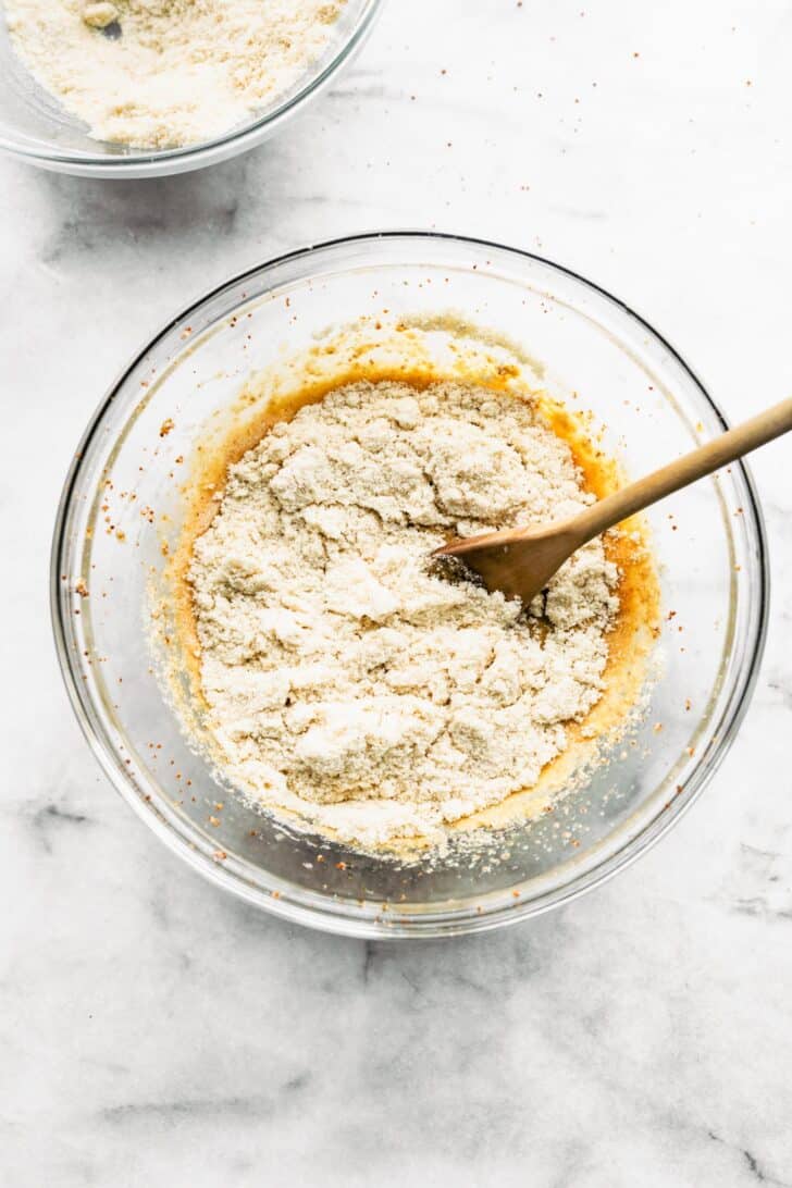 flour and egg batter in a bowl with a wooden spoon