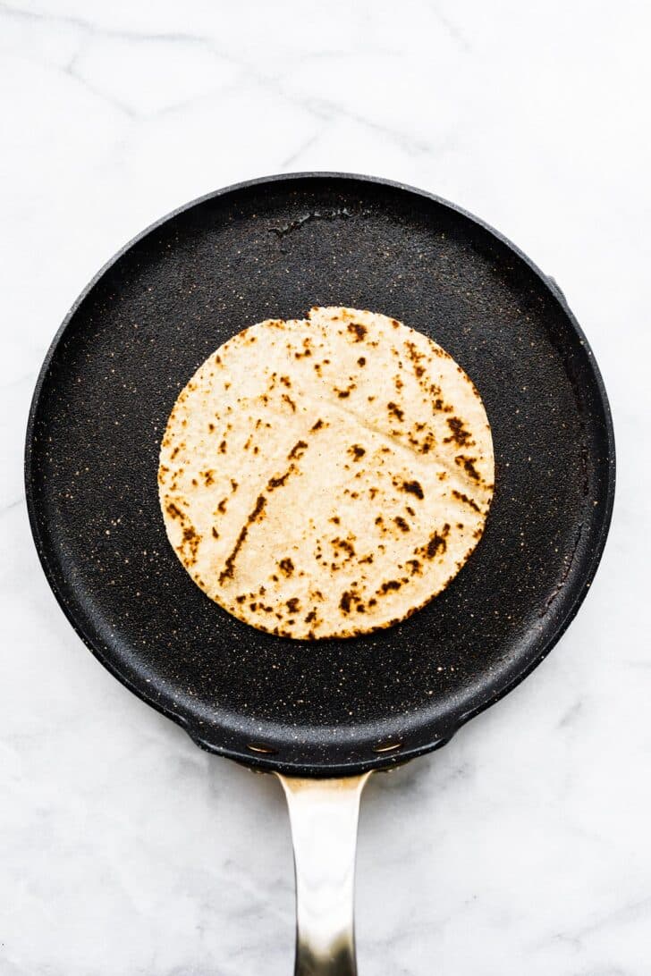 An almond flour tortilla in a skillet.