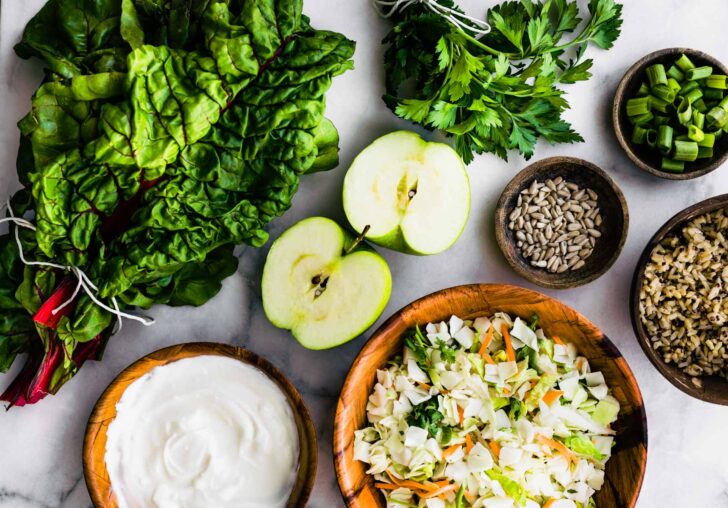 seasonal produce and other ingredients in bowls to make a vegan wraps recipe