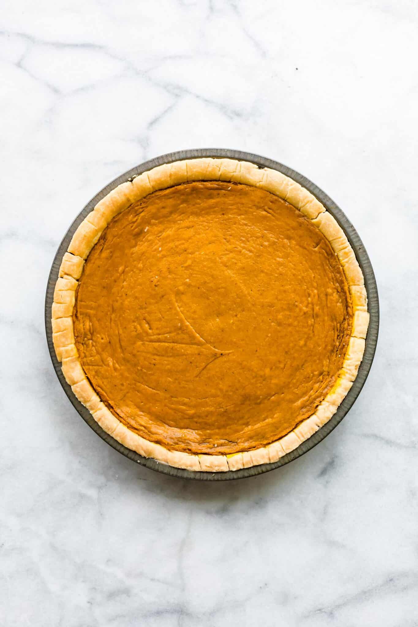 Overhead photo of a baked pumpkin pie with a gluten free pie crust.