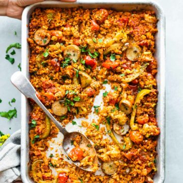 woman's hands holding rimmed baking sheet with Keto Mexican chorizo sheet pan dinner