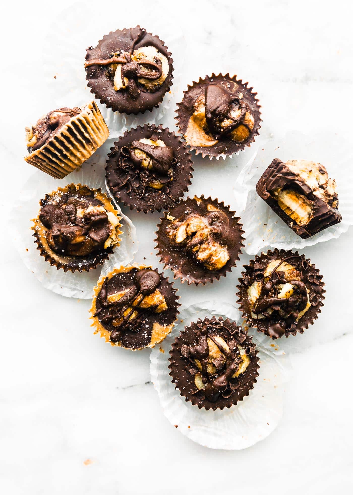 Ten Chocolate Almond Butter Cups with Banana displayed on a white marble countertop.