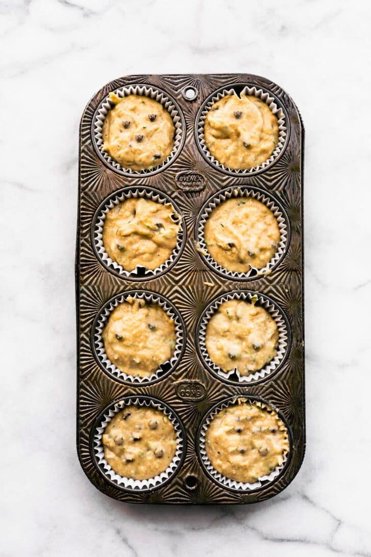 batter for chocolate chip protein muffins in a muffin pan