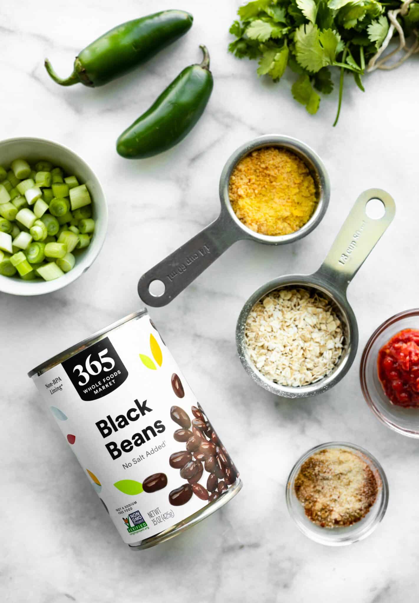 Ingredients for vegan black bean burgers on a white marble countertop.