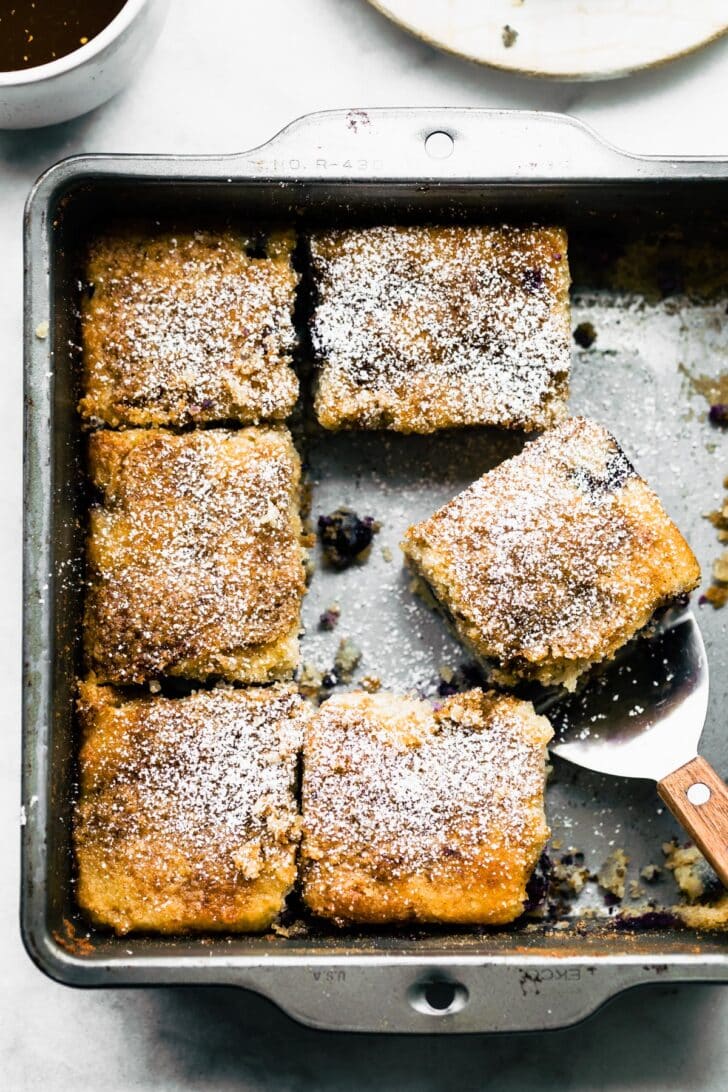 Overhead view coffee cake in baking dish topped with blueberries and crumble.