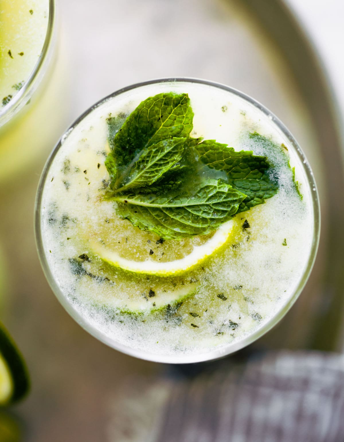 Overhead photo of Brazilian limeade in glass garnished with fresh mint and lime slices.