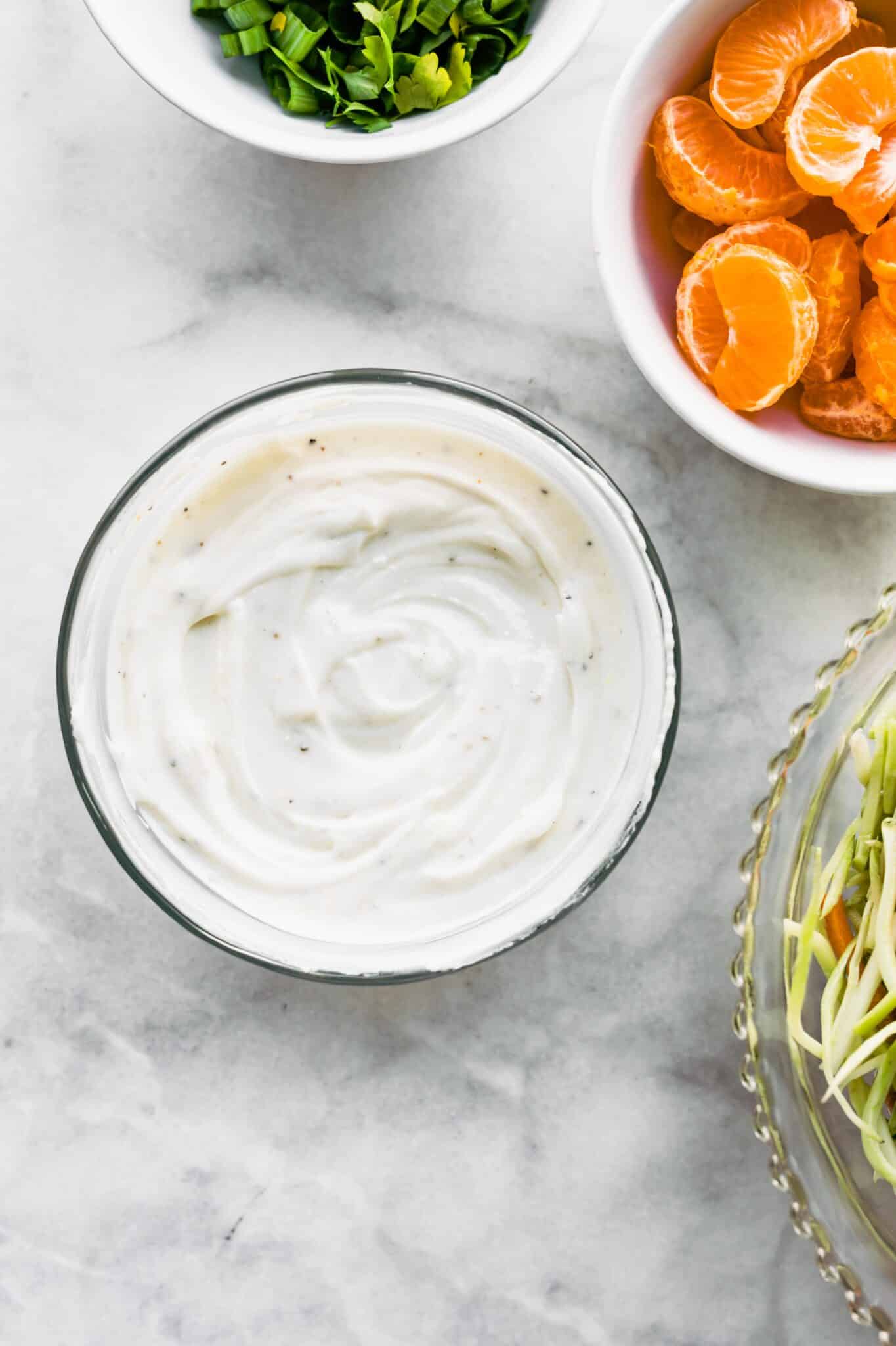 Overhead photo of a tangy homemade yogurt sauce in a glass bowl.