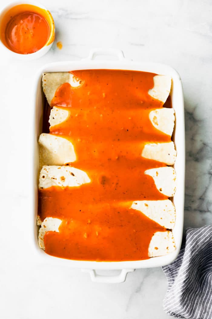 assembling an easy enchilada recipe in casserole dish