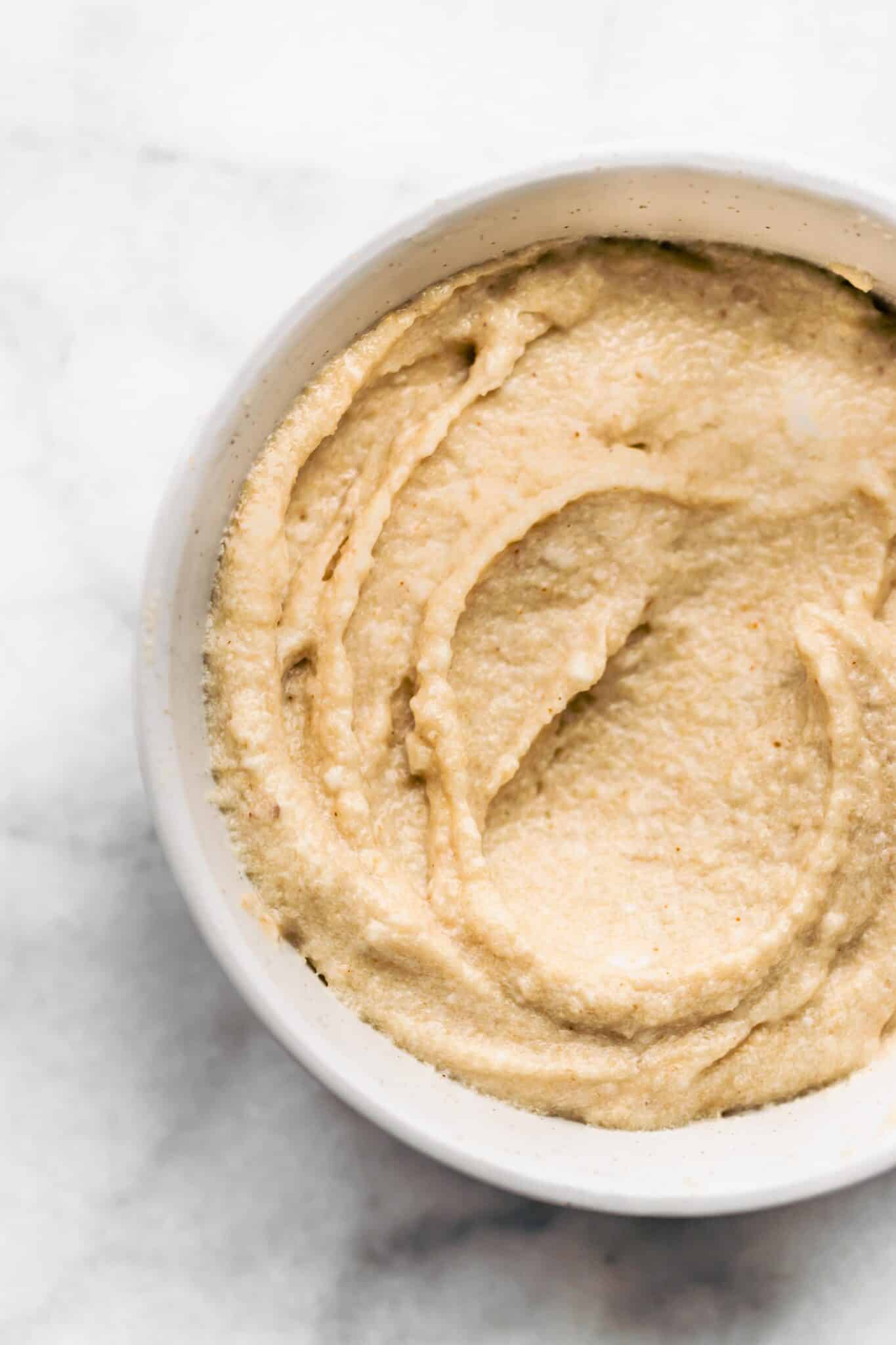 Up close overhead photo of maple cream cheese frosting in a white bowl.