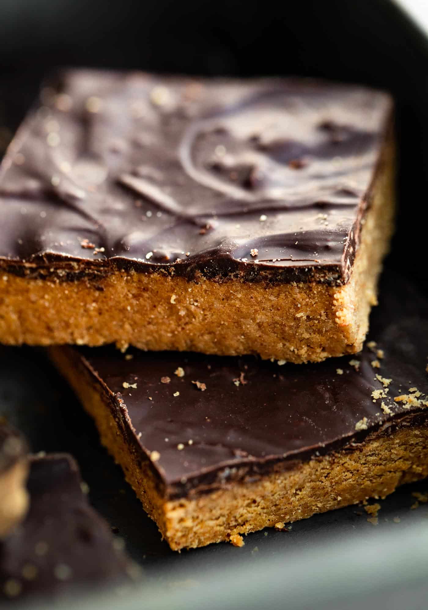 Almond flour bars topped with chocolate sitting askew in a metal pan.