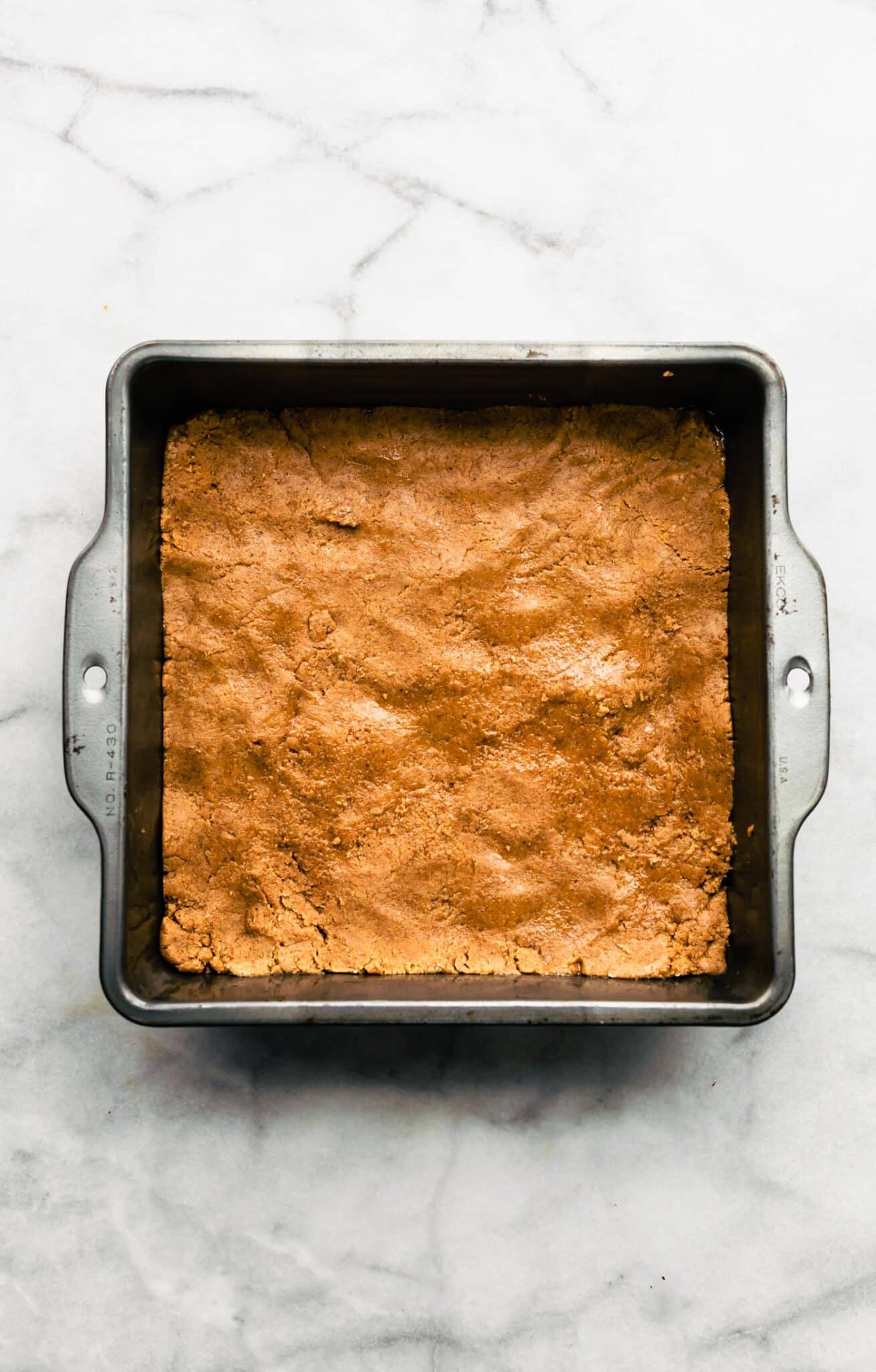 almond flour dough in a metal brownie pan.