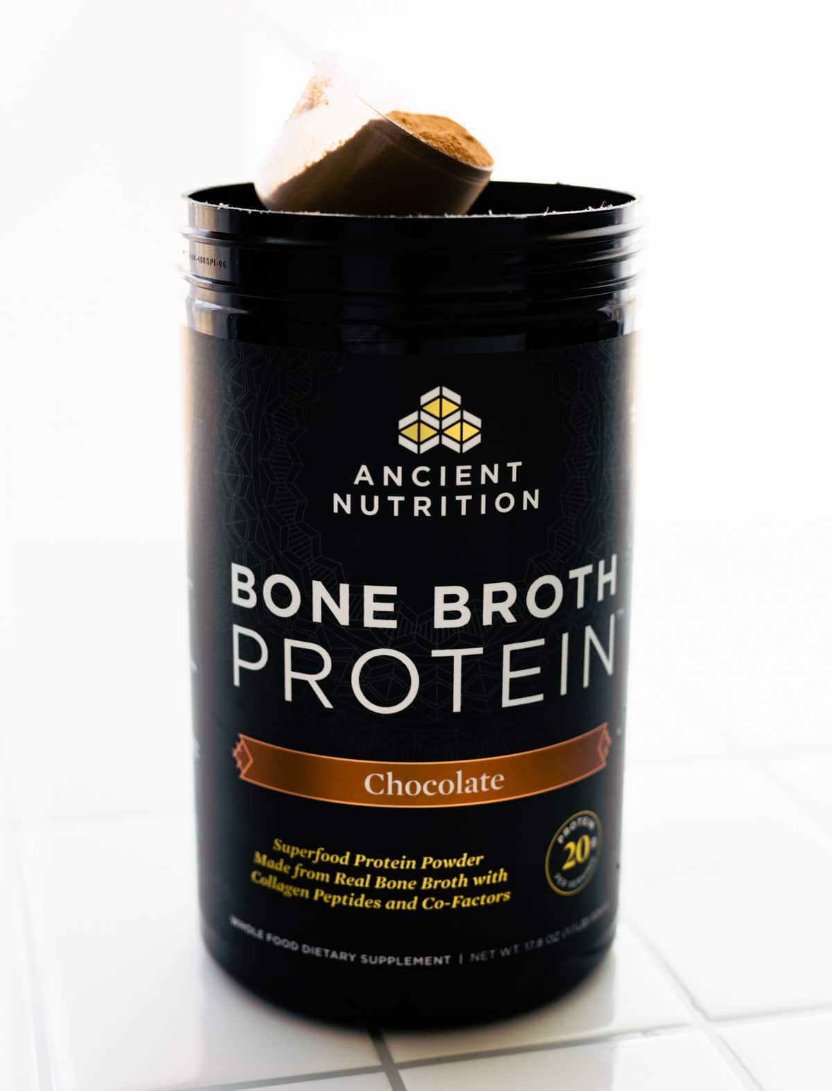 canister of Ancient Nutrition bone broth protein powder (chocolate flavor)