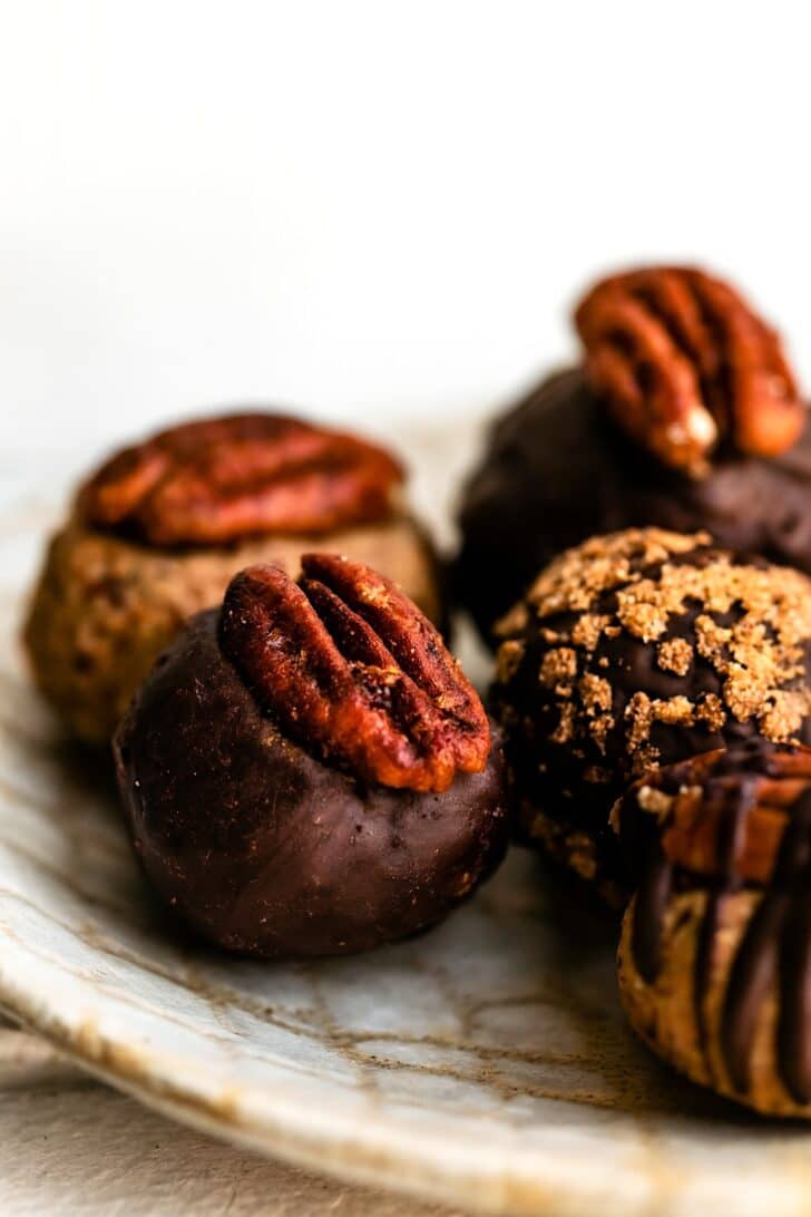 Close-up shot of chocolate dipped pecan pie balls on a plate