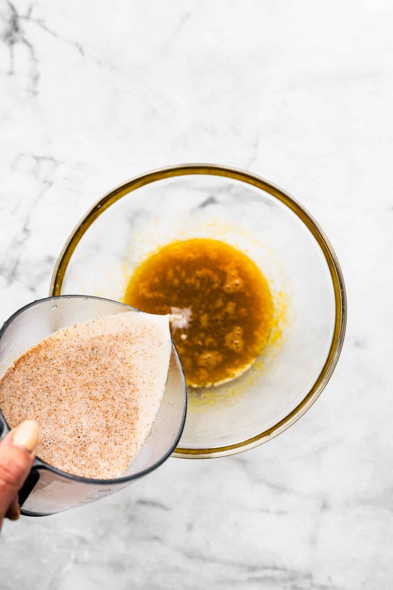 Tempering the egg yolk maple syrup mixture with warm coconut milk.