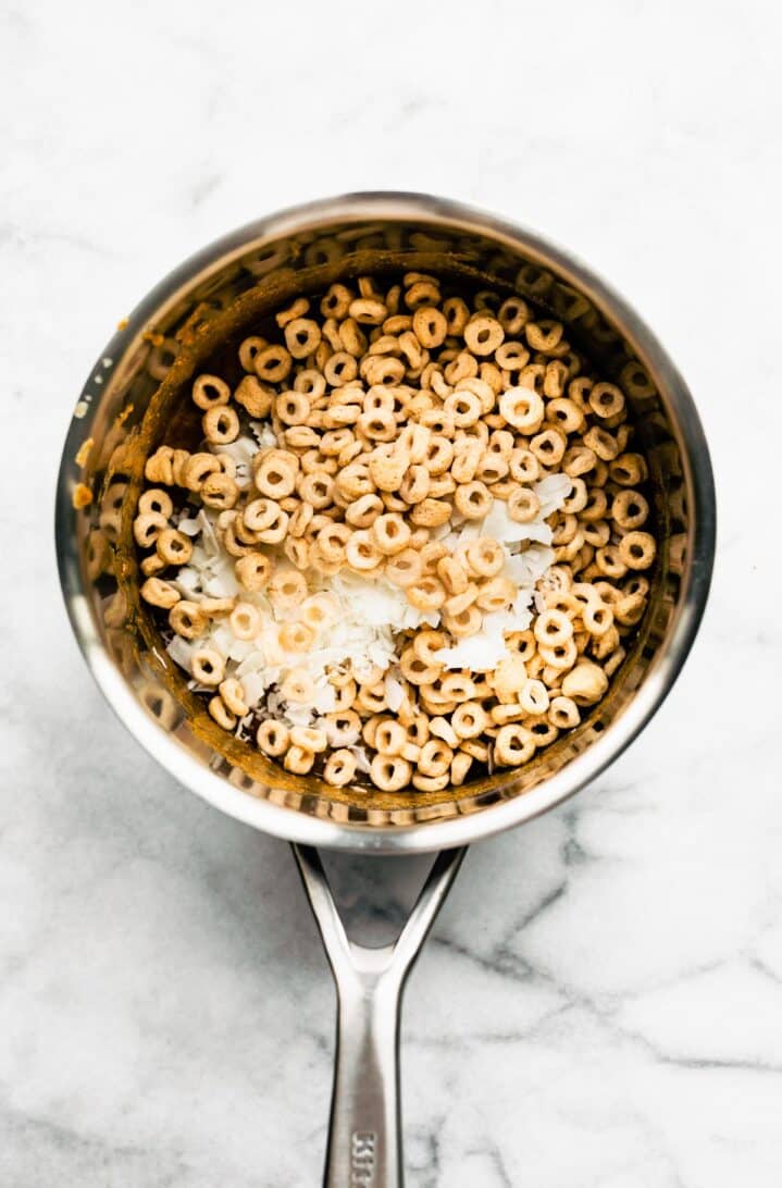 Gluten free cereal and shredded coconut in a metal saucepan.
