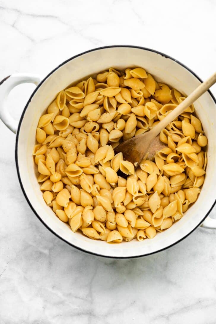 white pot of gluten free pasta with spoon in it.