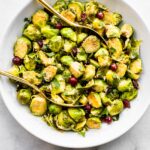 Two gold spoons in a roasted brussels sprout salad.