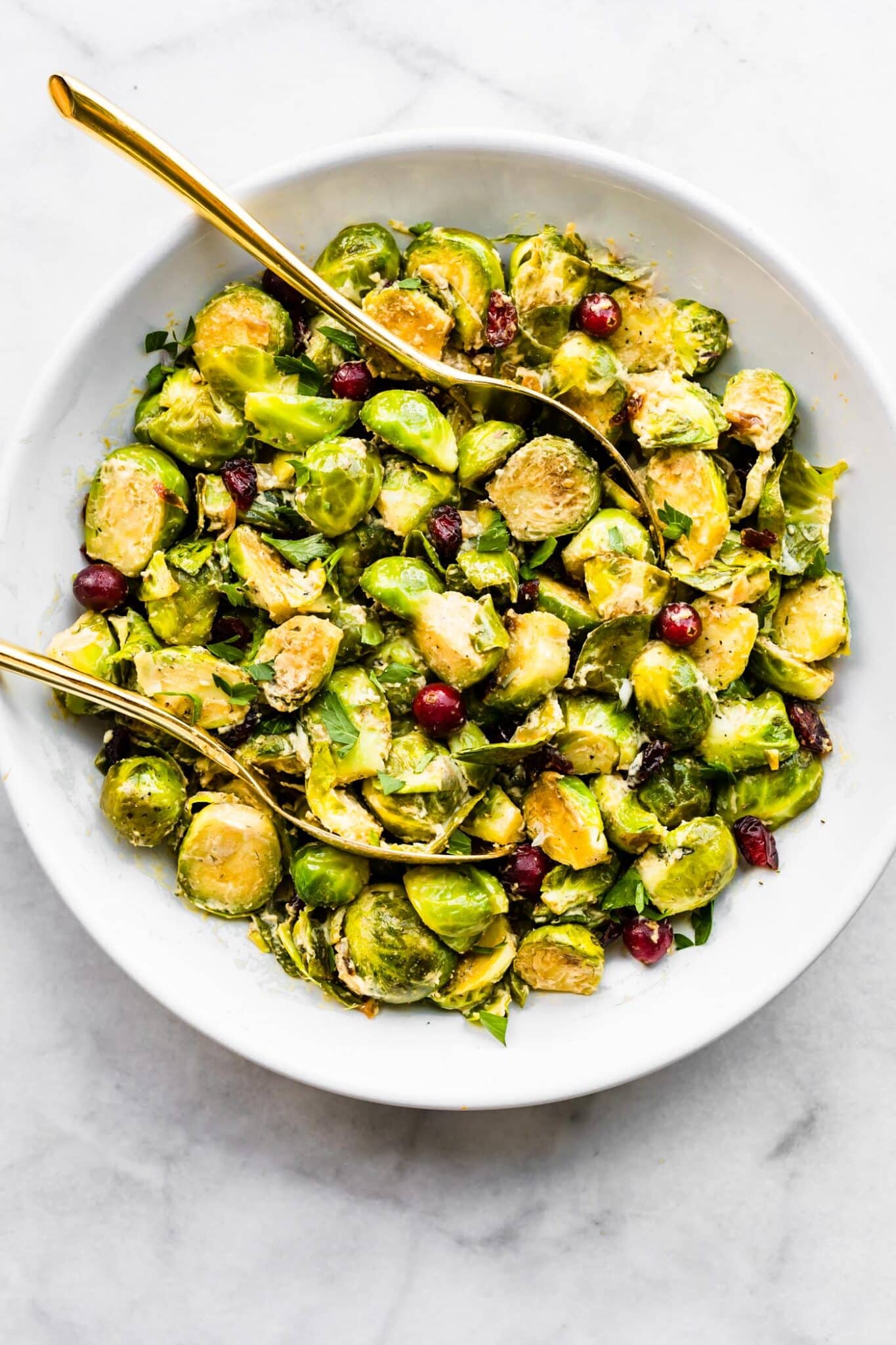 Two gold spoons in a roasted brussels sprout salad.