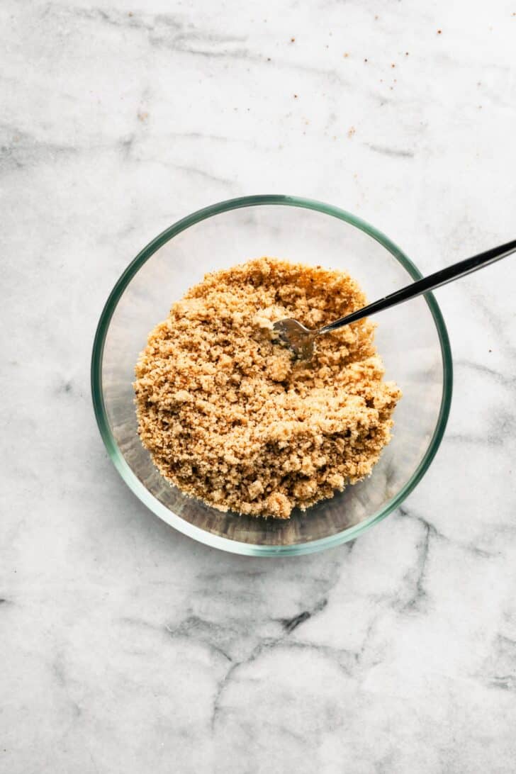 Almond flour crumble topping mixed in a bow with a fork in it