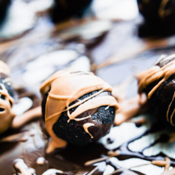 A single dark chocolate amaretto cake bite drizzle with nut butter and dark chocolate.