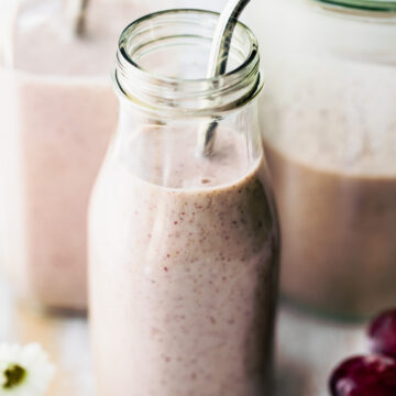frozen smoothie with grapes and yogurt in 2 glasses with straws.
