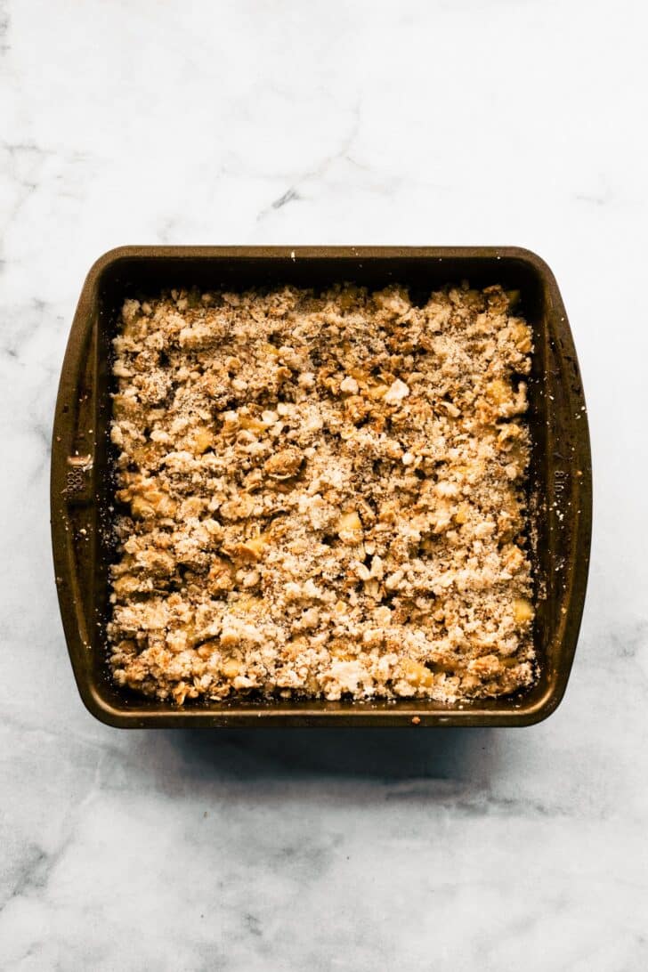 unbaked apple crisp bars topped with oat crumble mixture before baking.