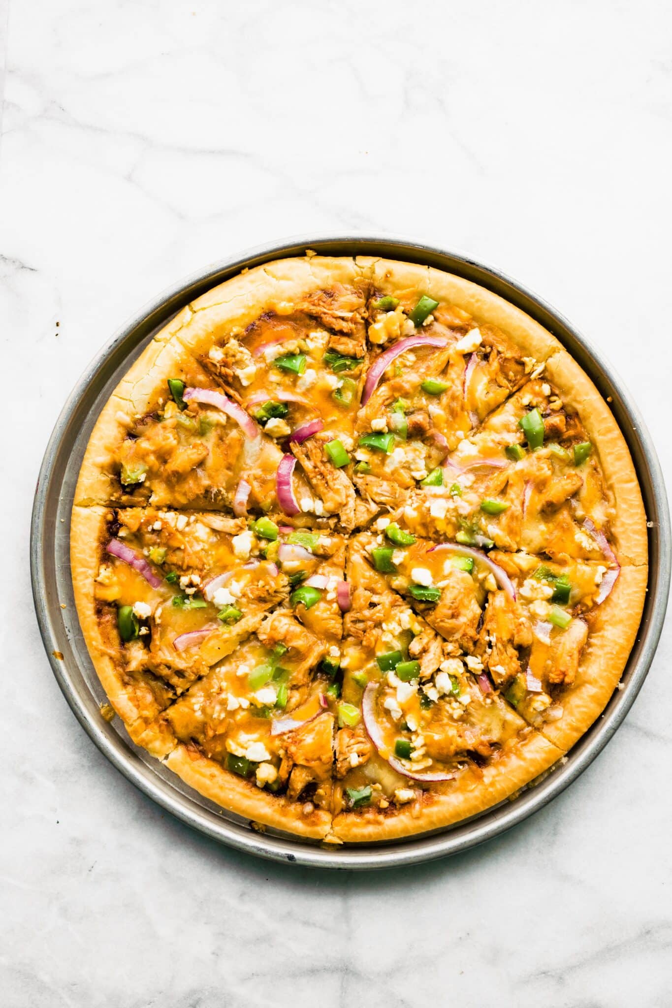Overhead photo of a gluten free BBQ chicken pizza topped with green onions.