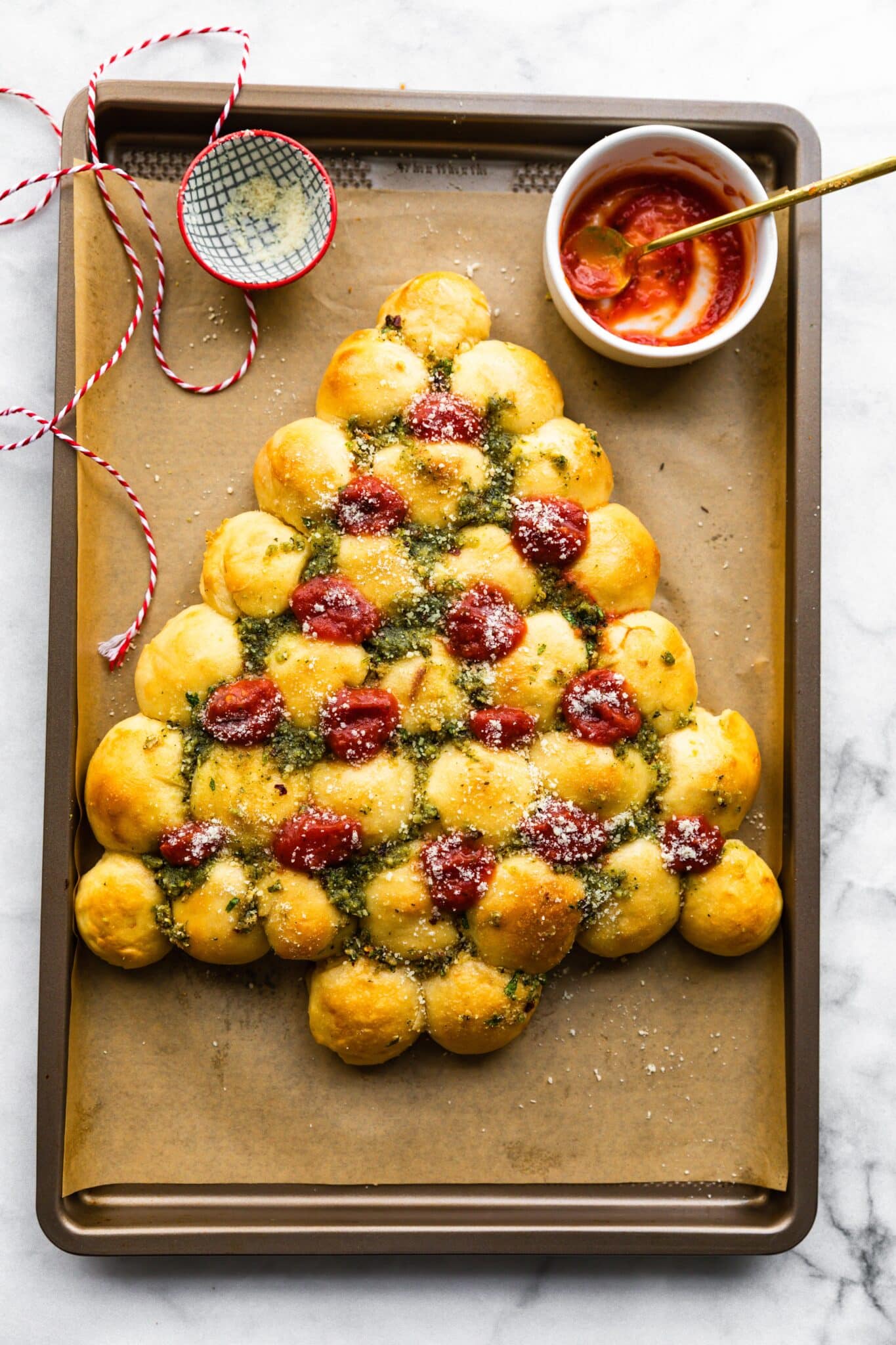 Beautiful photo of a gluten free Christmas tree pull apart bread topped with marinara.