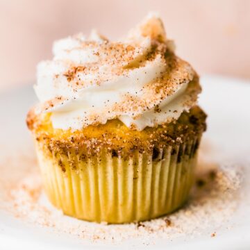 One cinnamon sugar churro cupcake on a white plate.