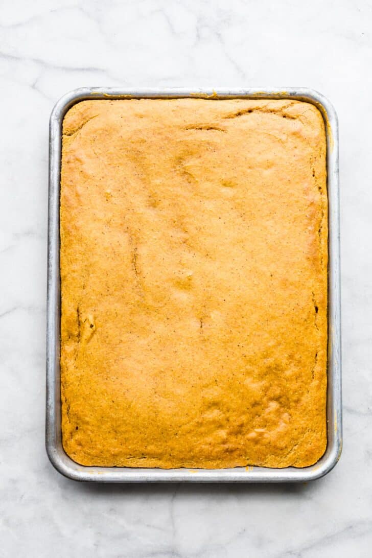 baked gluten free pumpkin bar batter spread on a sheet pan.