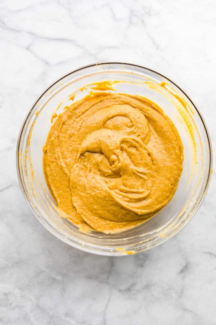 a bowl of mixed orange batter for gluten free pumpkin bars.